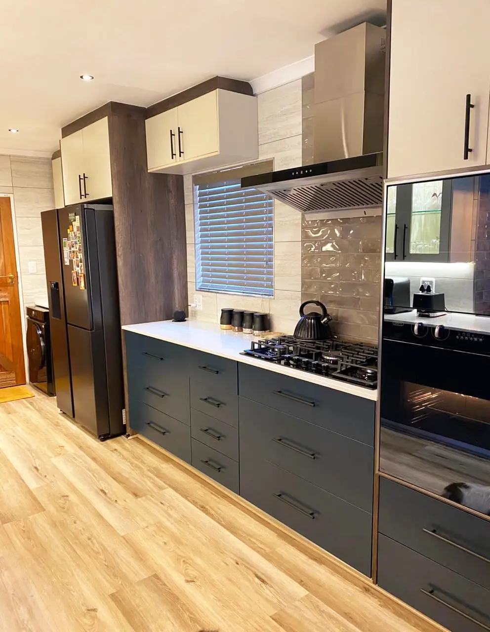 Modern kitchen cooking area with charcoal cabinetry and light worktops